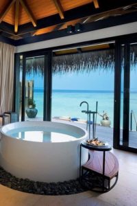 Photo of a round luxury bathtub overlooking a tropical ocean view